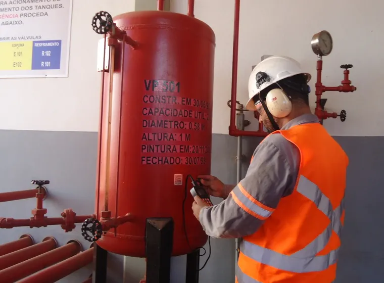 Técnico inspecionando vaso de pressão em área industrial