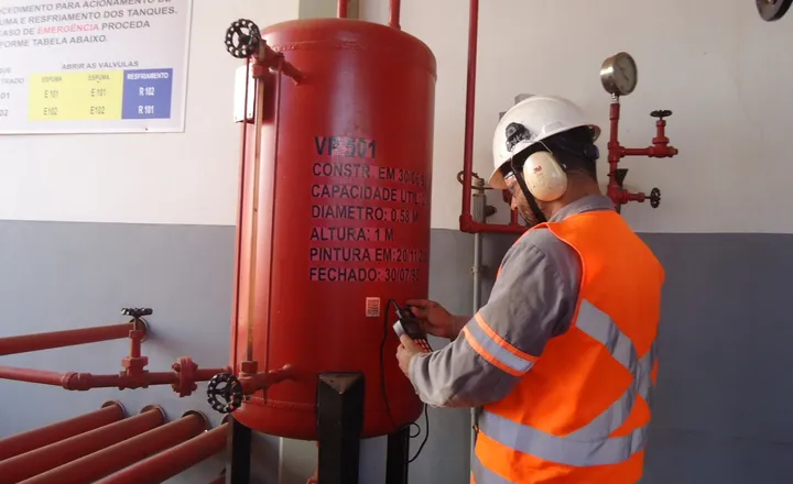 Técnico inspecionando vaso de pressão em área industrial