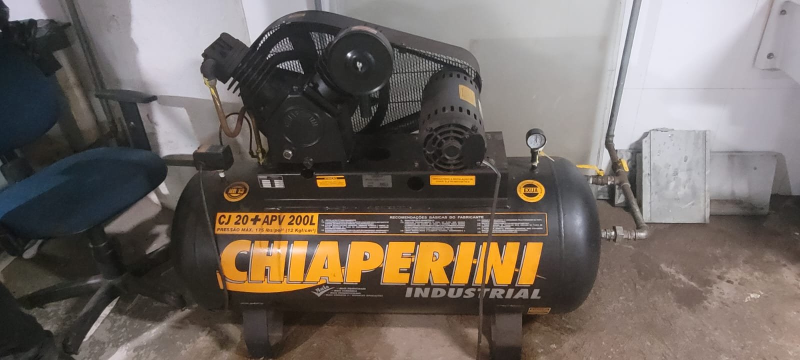 Compressor industrial com reservatório de ar comprimido em ambiente técnico