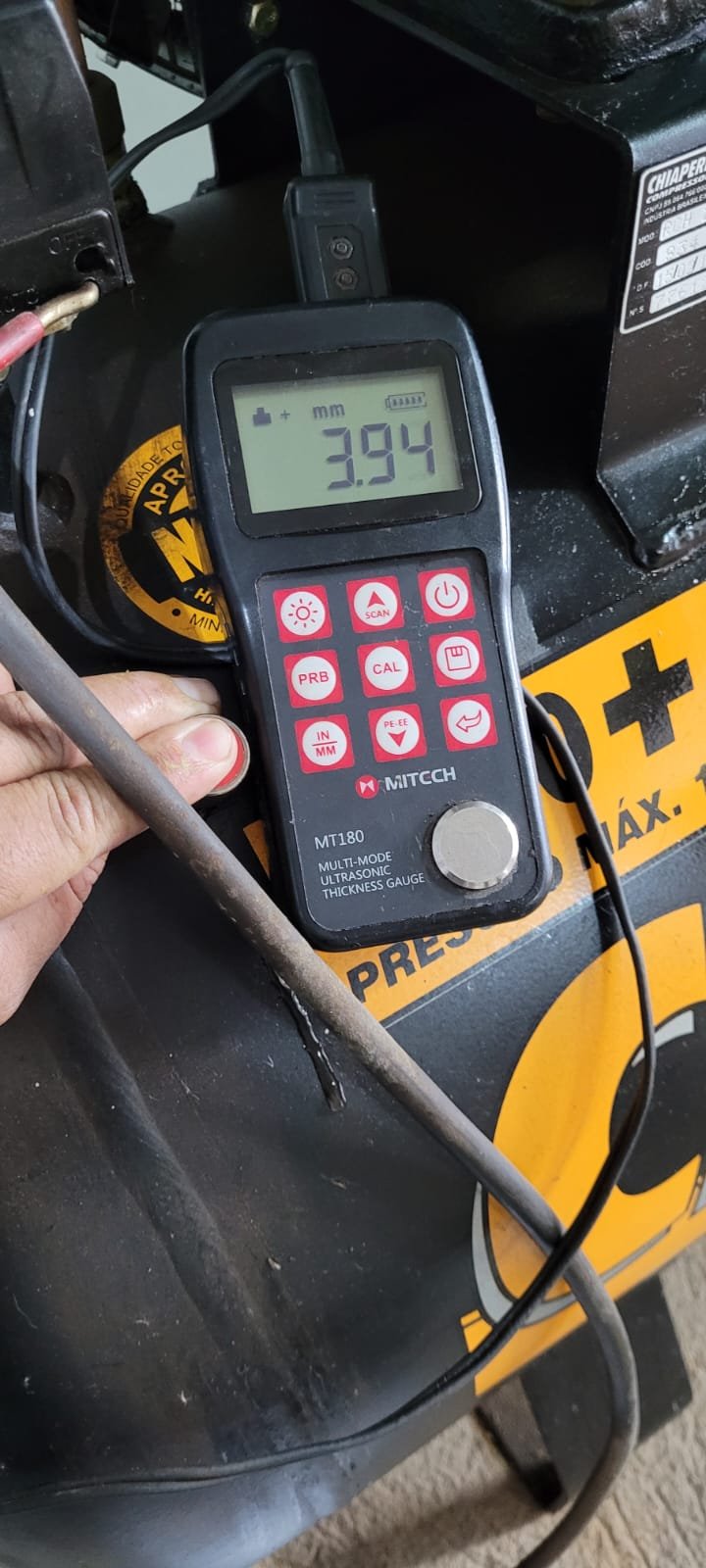 Medidor ultrassônico de espessura sendo utilizado em compressor industrial