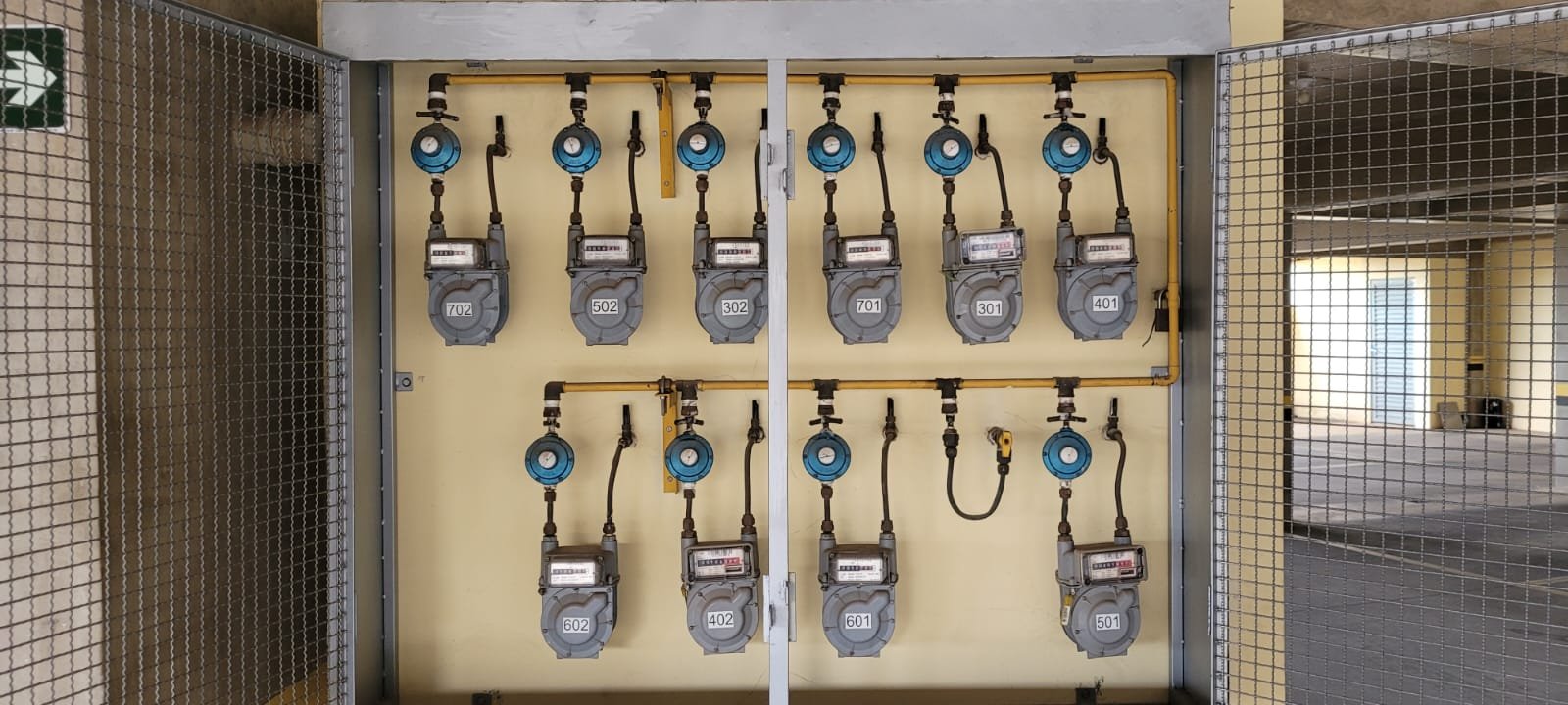 Painel grande com múltiplos medidores de gás em condomínio