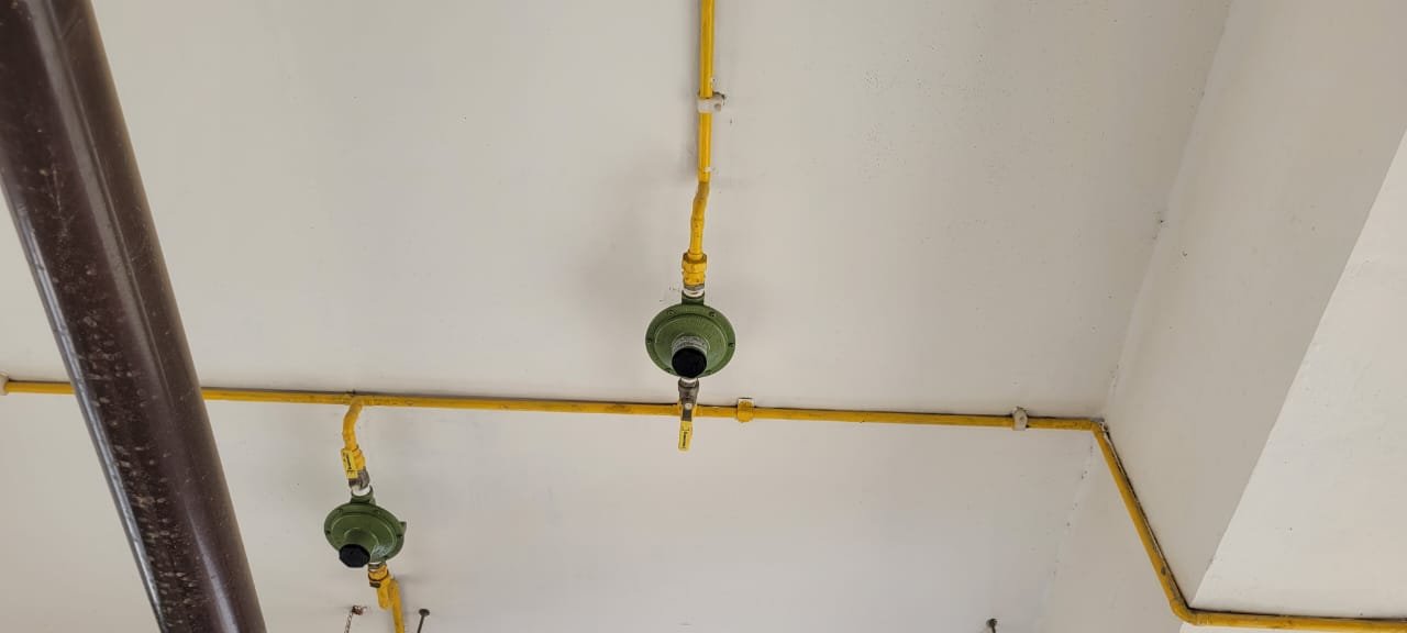 Tubulação amarela de gás com reguladores de pressão instalados em teto